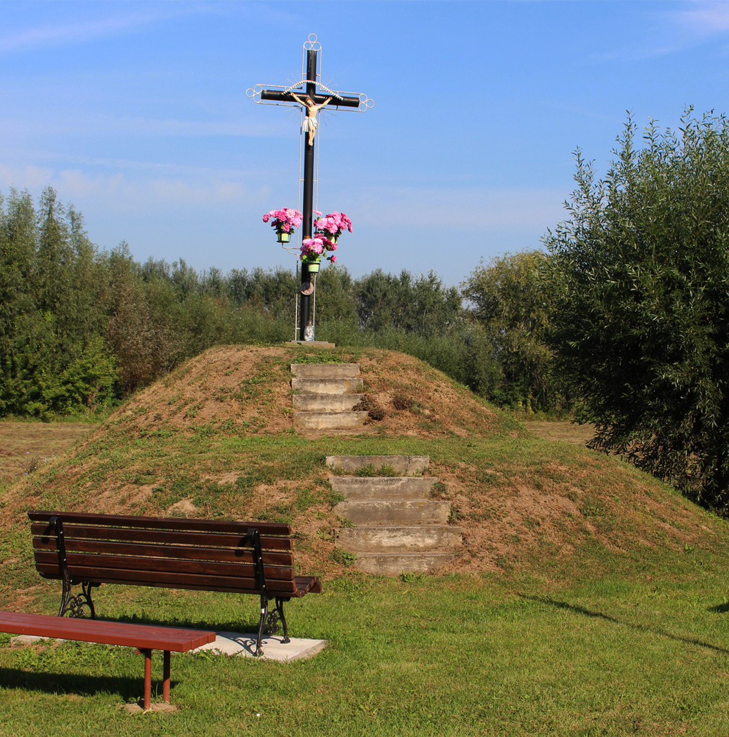 Zalesie Gorzyckie - Cypel. Krzyż ustawiony na kopcu, do którego prowadzą schody. Przed kopcem ustawione są ławki.