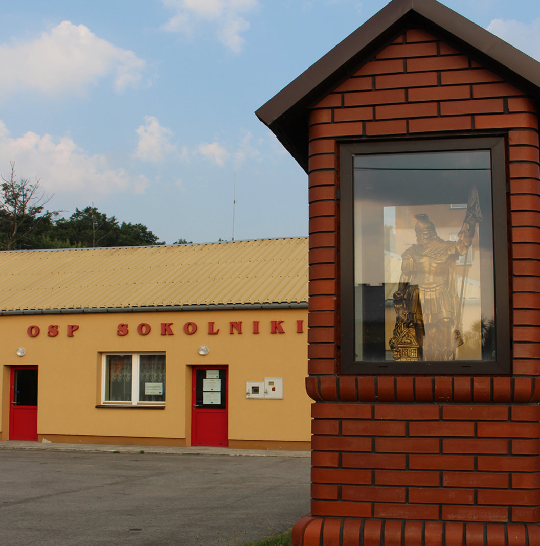 Sokolniki. Po prawej stronie kapliczka św. Floriana w tle remizja OSP Sokolniki